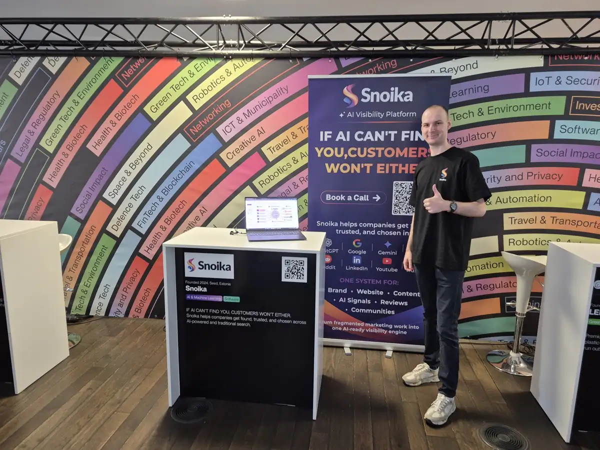 A Snoika team member at the Snoika stand next to the banner