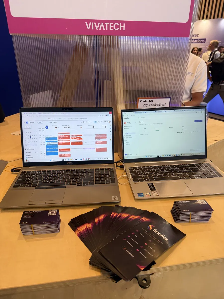 Two laptops and Snoika flyers on a stand table