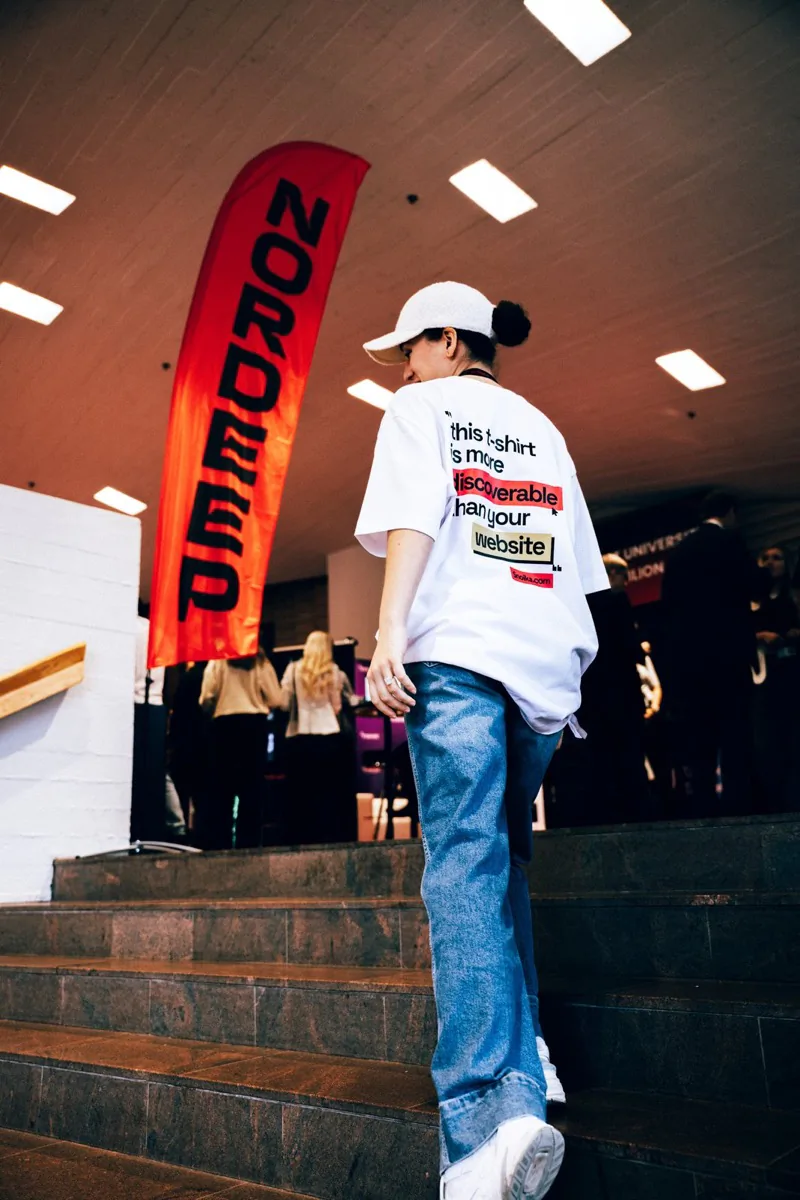A Snoika team member walking past a NORDEEP flag