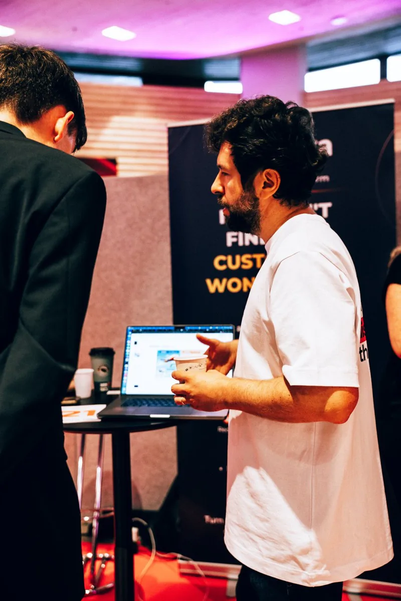 A Snoika team member showing a laptop demo to a visitor